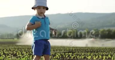 一个小孩子看着灌溉<strong>农田</strong>的设备。